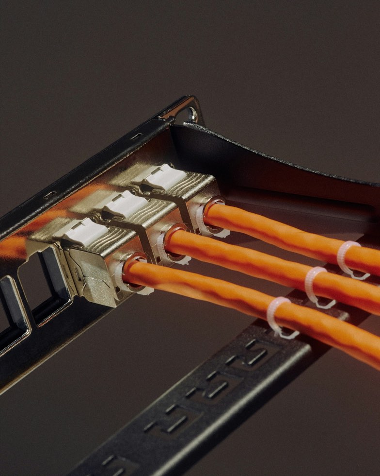 orange network fibers plugged into a port bank